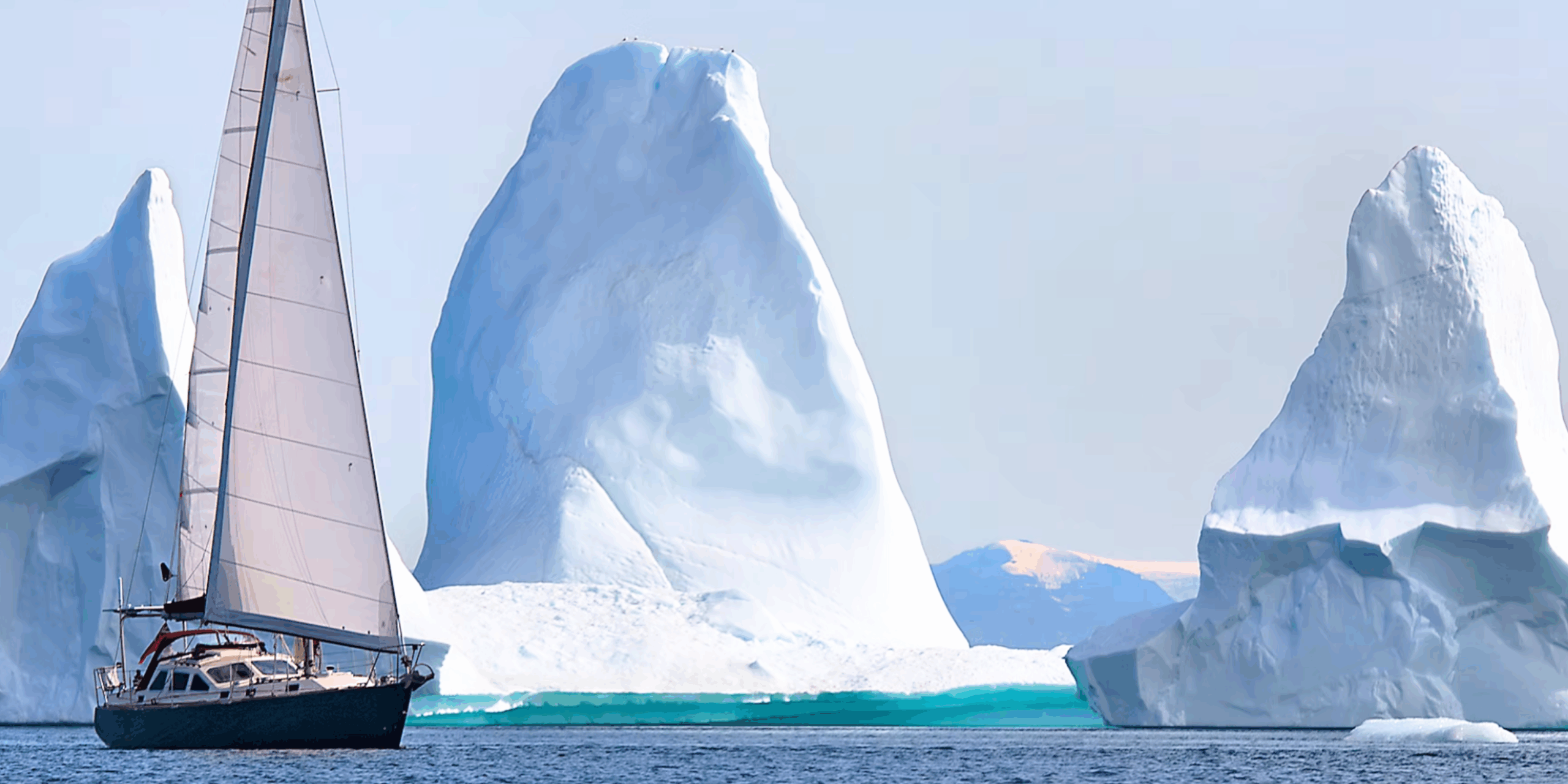voilier devant un iceberg en antarctique