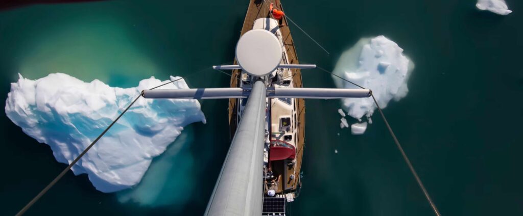 VUE DU HAUT DU MAT D'UN VOILIER PASSANT ENTRE DEUX PETITS ICEBERGS