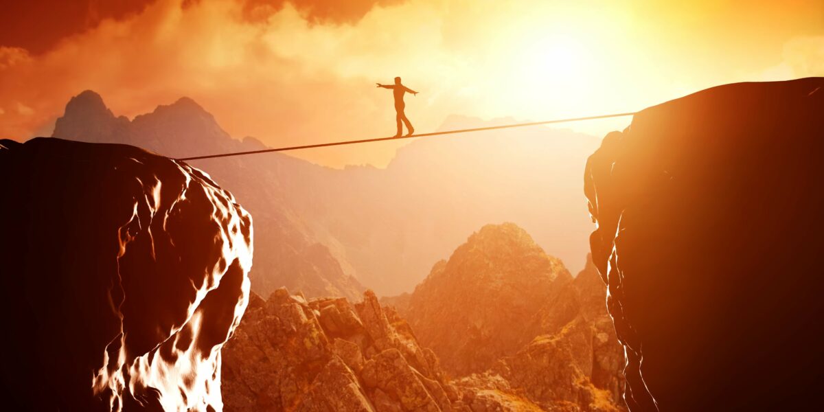 un funambule au dessus d'une vallée au coucher du soleil symbole de recherche d'équilibre en soi