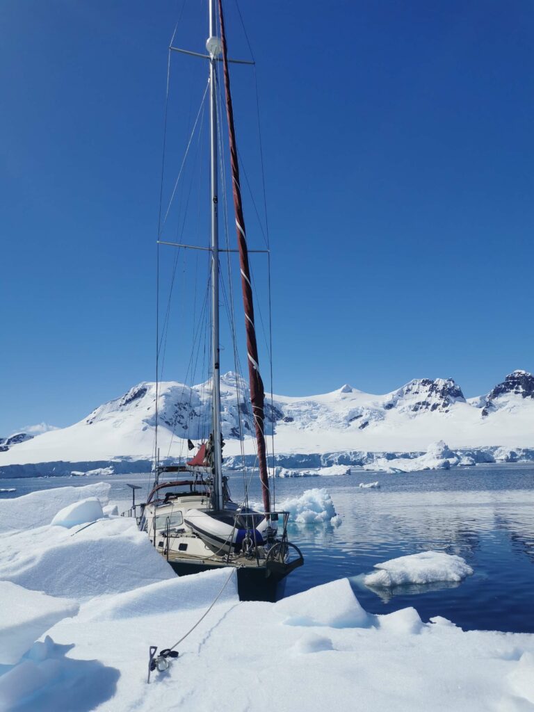 VOILIER EN ANTARCTIQUE AMARRÉ À UN ICEBERG